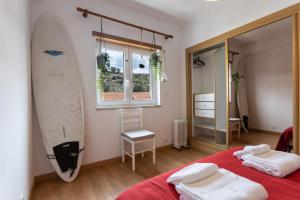 a bedroom with a surfboard hanging on the wall at Spacious Beach Flat in Costa Caparica by Soulplaces in Costa da Caparica
