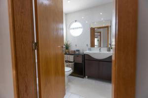 La salle de bains est pourvue d'un lavabo, de toilettes et d'un miroir. dans l'établissement Spacious Beach Flat in Costa Caparica by SoulPlaces, à Costa da Caparica