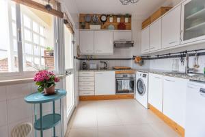 a kitchen with white cabinets and a blue stool at Spacious Beach Flat in Costa Caparica by Soulplaces in Costa da Caparica