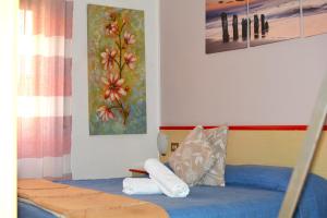 a bedroom with a bed with blue sheets and pillows at HOTEL LA MADUNINA in Varazze