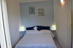 1 dormitorio pequeño con 1 cama y 2 lámparas en SUMMER HOUSE AL MARE, en Gaeta