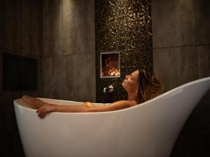 Una donna è seduta in una vasca da bagno di Clandeboye Lodge Hotel a Bangor