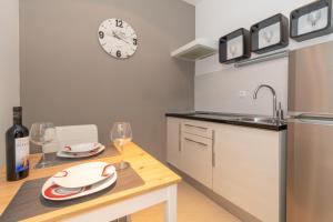 une cuisine avec une table, des verres à vin et une horloge dans l'établissement Rony studio, à Split