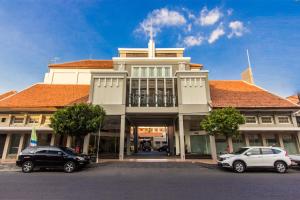 two cars parked in a parking lot in front of a building at Hotel Quirin in Semarang