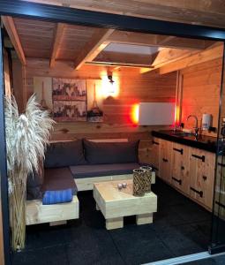 a living room with a couch and a kitchen at Wellness Bungalow Bolder 5p Amsterdam and the beach in Opmeer