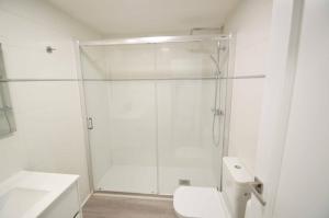 a white bathroom with a shower and a toilet at Apartamento Encanto Tarazona in Tarazona de Aragón