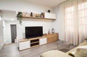 sala de estar con TV de pantalla plana en un centro de entretenimiento en Apartamento Encanto Tarazona, en Tarazona de Aragón