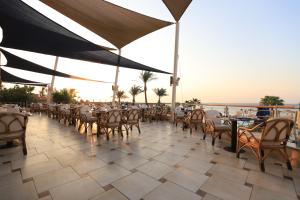 a restaurant with tables and chairs and a view of the ocean at Shams Prestige Abu Soma (Adults Only) in Hurghada