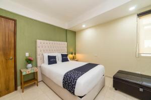 a bedroom with a large white bed and green walls at Casa Santa Fe, Guanajuato in Guanajuato