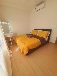 a bedroom with a bed with yellow sheets and a table at Wallaway2stay Gravit8 Klang 2Room in Klang