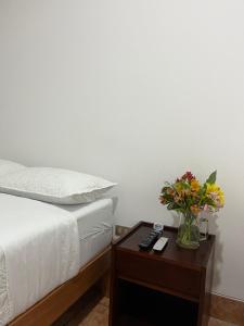 a bedroom with a bed and a table with a vase of flowers at Rosa Estela in Cieneguilla