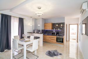 a kitchen and dining room with a table and chairs at Apartments Sandito in Mlini