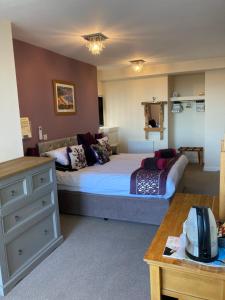 a bedroom with a large bed and a dresser at The Quies in Newquay