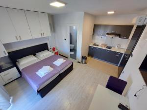 a small bedroom with a bed and a kitchen at Apartments Daniel in Vodice