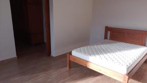 Ce lit se trouve dans un dortoir doté d'un cadre de lit en bois. dans l'établissement Pirassununga, SP - Casa 3 suítes em condomínio RURAL - 06 hóspedes Confortáveis, à Pirassununga