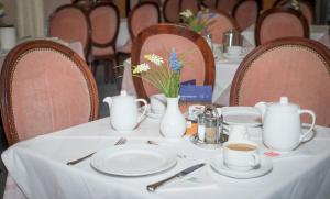 a table with white dishes and vases on it at Pension Neuer Markt in Vienna