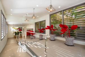 a hallway with vases with red flowers in them at Olé Tropical Tenerife Adults Only in Playa de las Americas