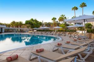 a pool at a resort with lounge chairs and umbrellas at Olé Tropical Tenerife Adults Only in Playa de las Americas