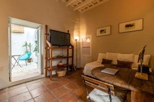 タリファにあるAzogue suites con patio privadoのベッドルーム(ベッド1台、テーブル、テレビ付)