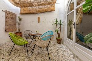 タリファにあるAzogue suites con patio privadoのパティオ(椅子、テーブル、鉢植えの植物付)