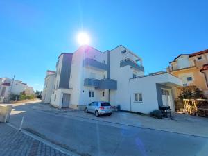 a car parked in front of a white building at Apartments Daniel in Vodice
