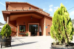ein Haus mit zwei Bäumen davor in der Unterkunft Hotel Valdevécar in Albarracín