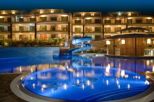 basen ze zjeżdżalnią wodną przed budynkiem w obiekcie Topola Skies Resort & Aquapark w mieście Topola
