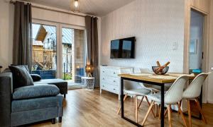 a living room with a table and chairs and a couch at Apartamenty Kuracyjna in Jastrzębia Góra