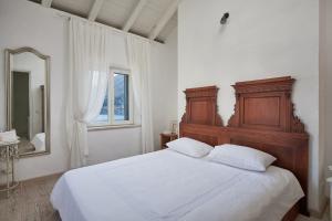 a bedroom with a large bed and a mirror at Mala kuća Sobra in Sobra