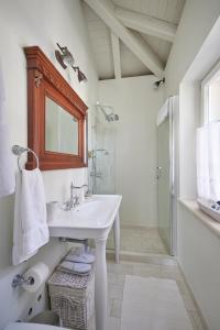 a white bathroom with a sink and a shower at Mala kuća Sobra in Sobra