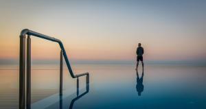 Ein Mann steht im Wasser neben einer Schiene. in der Unterkunft Topola Skies Resort & Aquapark in Topola