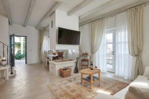 a living room with white walls and a tv at Mala kuća Sobra in Sobra