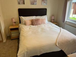 Un dormitorio con una cama con dos almohadas encima. en Mandarin Lodge with Hot Tub, en Malton