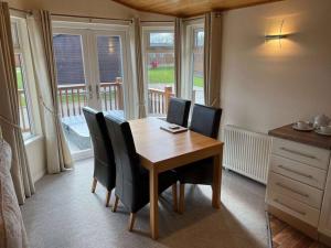 Un comedor con mesa y sillas de madera. en Mandarin Lodge with Hot Tub, en Malton