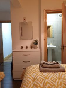 ein Schlafzimmer mit einer Kommode mit einem Spiegel und einem Waschbecken in der Unterkunft Homebird Property - Conway House in Leeds