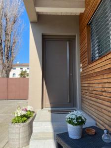 einer Haustür eines Hauses mit zwei Topfpflanzen in der Unterkunft CASA MARLU in Vicenza