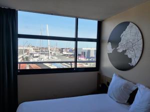 a bedroom with a window with a map of the world at B&B HOTEL La Rochelle Centre Les Minimes in La Rochelle