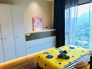 a bedroom with a yellow bed and a window at Genting Geo 38 #New#Near Skyway # Premium Outlet in Genting Highlands