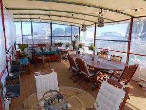 a dining room on a boat with a table and chairs at PENICHE FARNIENTE CLIMATISEE - Aux Portes de la Camargue in Bellegarde