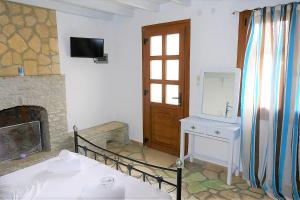 a room with a fireplace and a sink and a mirror at Jasmine apartments in Pythagoreio