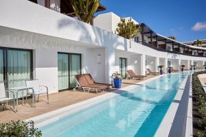 
a hotel room with a pool and a balcony at Secrets Lanzarote Resort & Spa - Adults Only (+18) in Puerto Calero
