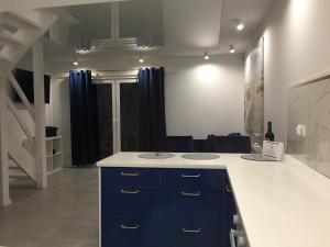 a kitchen with a sink and blue cabinets in a room at Domki Meer Dziwnówek in Dziwnówek