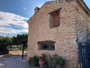 a brick building with a window on the side of it at Caseta dels Cirerers in Masdenverge