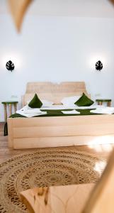 1 dormitorio con 1 cama grande con almohadas verdes en Conacul Olarilor, en Baia de Fier
