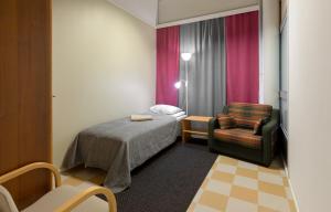 Camera piccola con letto e sedia di Hostel Eduskunta a Kauhajoki