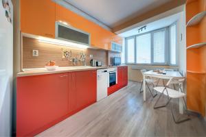 una cocina con armarios naranjas y una mesa blanca en Daisy - 3 Room and kitchen apartment in Lazur, en Burgas