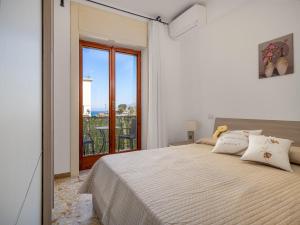 um quarto com uma cama e uma grande janela em ENEA apartment in Sorrento center em Sorrento