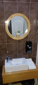 a bathroom with a sink and a mirror on a wall at WW Hostel & Suites in Coimbra