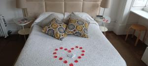 a bed with two hearts on it with two tables at WW Hostel & Suites in Coimbra