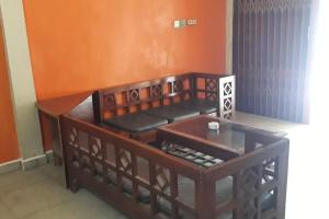 ein Zimmer mit zwei Holzstühlen und einer orangefarbenen Wand in der Unterkunft Oma Homestay Pagar Alam Syariah RedPartner in Pagaralam